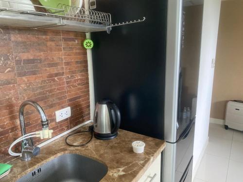 Ban KataにあるChristian Apartamentのシンクとレンガの壁のあるキッチン