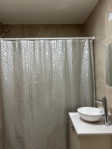 a bathroom with a shower curtain and a sink at Depto en Garden Puerto Santa Fe in Santa Fe