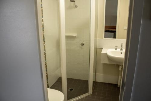 Un baño con ducha, lavabo e inodoro. en BATHURST GOLDFIELDS MOTEL at 428 CONROD STRAIGHT MOUNT PANORAMA, en Bathurst