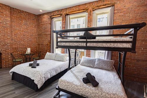 two bunk beds in a room with a brick wall at JGSTAY - Koreatown in New York
