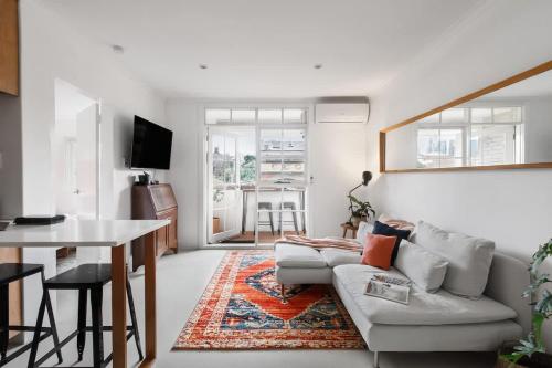 a living room with a couch and a table at Stylish 1-Bed Apt with Parking in Heart of Fitzroy in Melbourne