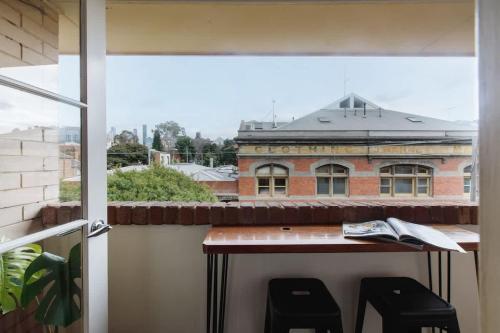 a balcony with a table and two stools at Stylish 1-Bed Apt with Parking in Heart of Fitzroy in Melbourne