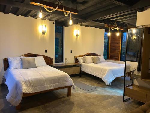 a bedroom with two beds and a mirror at Montearroyo Gualea lodge 