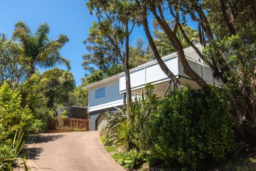a house with a road leading to it at Bay Haven - Walk to Palm Beach in Waiheke Island