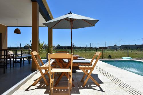 a table and chairs with an umbrella next to a pool at Quinta Natural Glam in San Vicente
