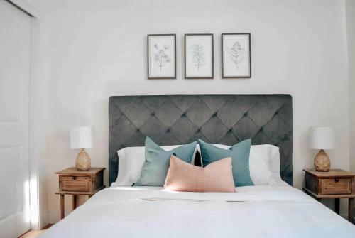 プティット・リヴィエール・サン・フランソワにあるChalet La Rocheuse et SPAのベッドルーム1室(ピンクとブルーの枕が付いた大型ベッド1台付)