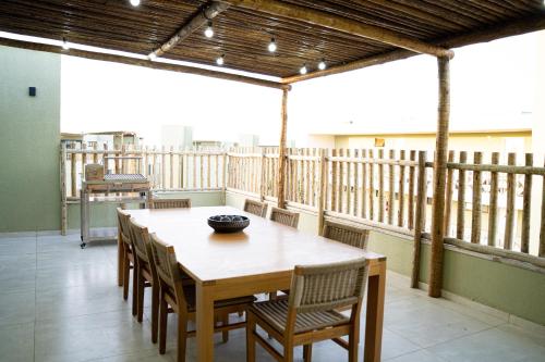 a wooden table and chairs on a balcony at Oásis Vistamar in Luis Correia