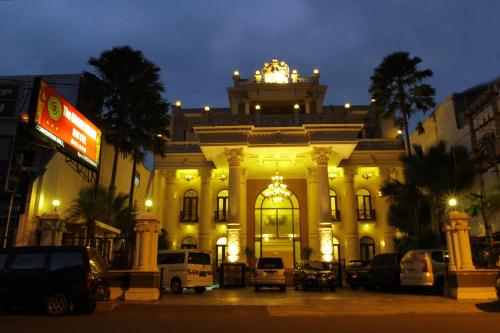 a large building with cars parked in front of it at The Grand Palace Hotel Malang in Malang