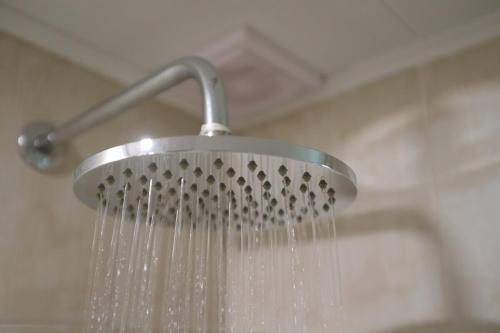 a shower head with water pouring out of it at Luxury Triplex Penthouse with Balcony and Stunning Mountain Views in Bogotá