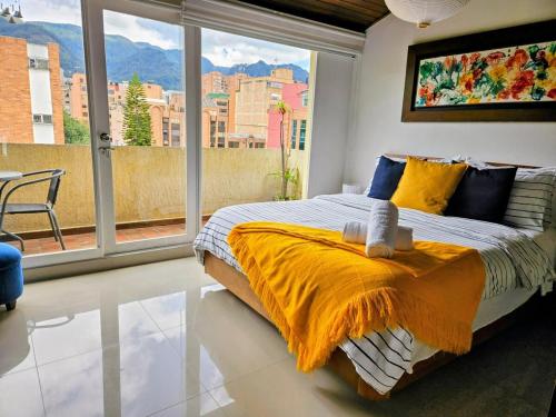 a bedroom with a large bed and a large window at Luxury Triplex Penthouse with Balcony and Stunning Mountain Views in Bogotá