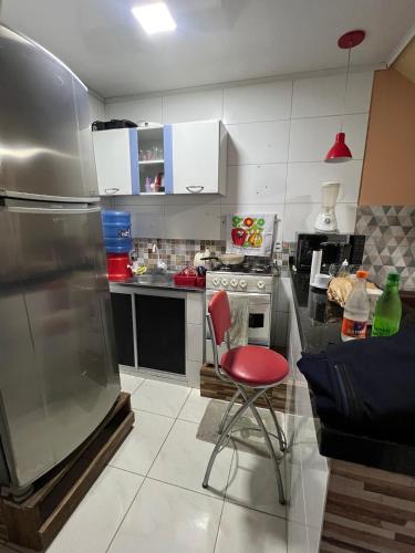 eine Küche mit einem roten Stuhl und einem Herd in der Unterkunft Furnished Apartment Type House for COP30 in Belém