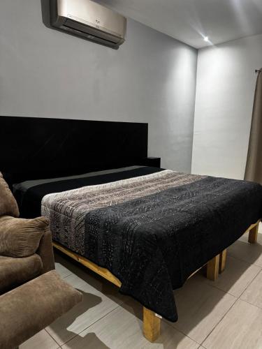 um quarto com uma cama com um edredão preto em The CaSa em Saltillo