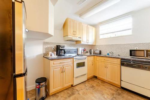 una cocina con armarios de madera y electrodomésticos blancos en Tempe, en North Vancouver
