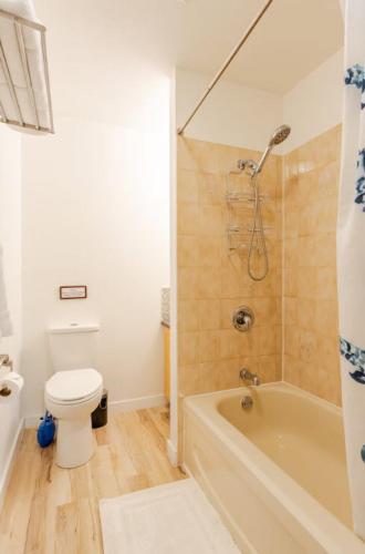 a bathroom with a tub and a toilet and a shower at Spacious & Cozy 1 Bedroom Suite in North Vancouver in North Vancouver