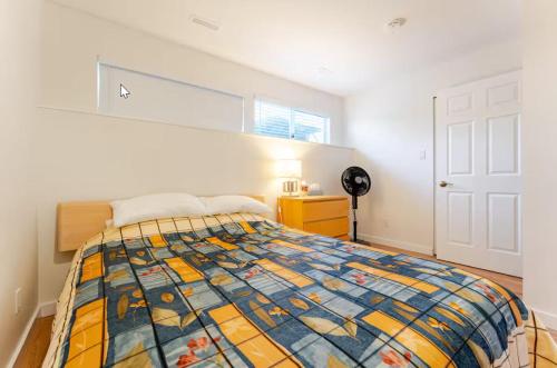 1 dormitorio con 1 cama con colcha colorida en Tempe, en North Vancouver