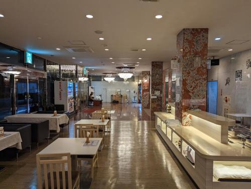 a restaurant with tables and chairs in the middle at Asia Hotel Narita in Narita