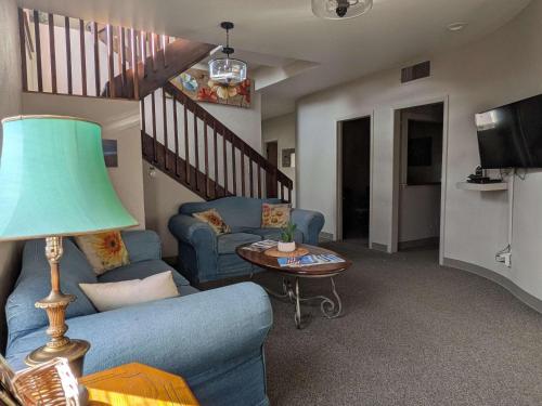 a living room with a blue couch and a table at Group Basecamp 6 Bedrooms Downtown GJ in Grand Junction