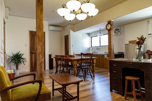 a kitchen and dining room with a table and chairs at ゲストハウスおと in Nachikatsuura