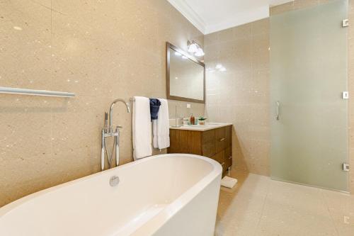 a bathroom with a tub and a sink and a mirror at Dream Diamond in Saint Annʼs Bay