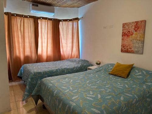 a bedroom with two beds and a window at Los mangos Posadamanabita in Portoviejo