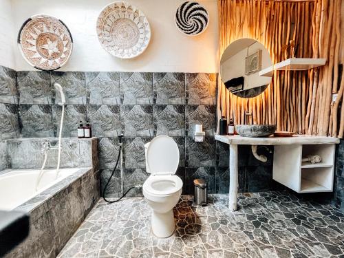 une salle de bain avec toilettes, lavabo et baignoire dans l'établissement Bingin Sun & Moon Villas, à Bingin Beach