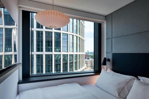 um quarto com uma cama e uma janela grande em citizenM Boston Back Bay em Boston