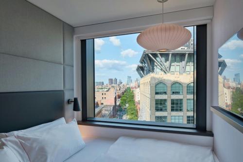 a bedroom with a window with a view of a city at citizenM Boston Back Bay in Boston