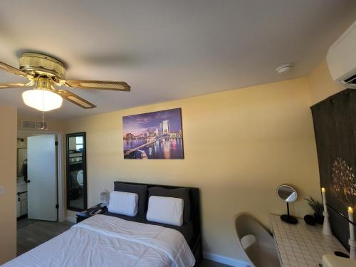 een slaapkamer met een bed en een plafondventilator bij Twin Pines Studios in Jacksonville