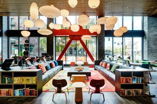 a library with couches and chairs and tables and windows at citizenM Seattle Pioneer Square in Seattle