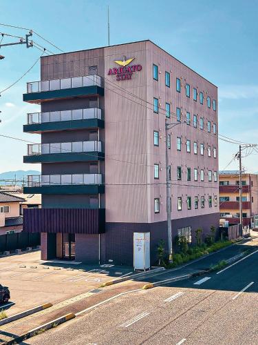 a large building with anadobeadobeadobe signage on the side of it at Arigato Stay Suzuka in Suzuka