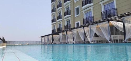 a large swimming pool in front of a building at Cozy Suite - Near UTAR - Champs Elysees Kampar in Kampar