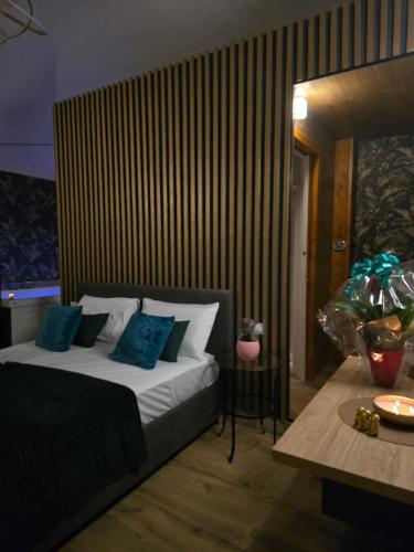 a bedroom with a bed with blue pillows and a table at Rifugio Borbonico in Portici