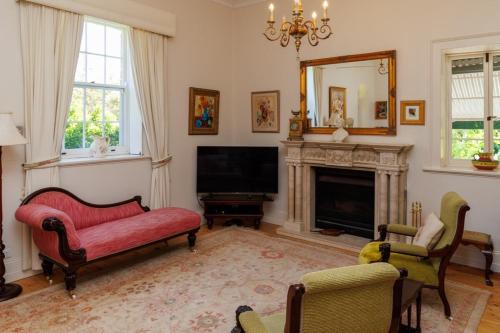 a living room with a fireplace and a tv at The Olives Heritage House in Yankalilla