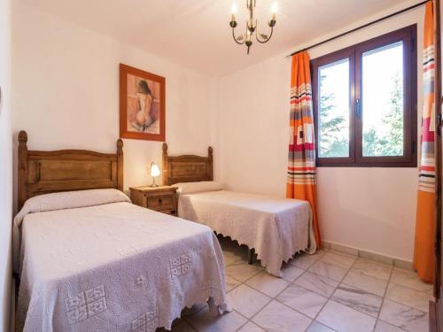a bedroom with two beds and a window at Scenic Bungalow Retreat in Pozo Alcon in Cuenca
