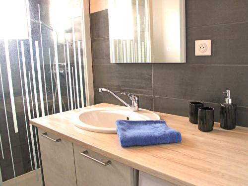 ein Waschbecken im Bad mit einem blauen Handtuch auf der Theke in der Unterkunft Gîte Chez Mamie - Charme Vintage près de Lavoine - FR-1-489-332 in Lavoine