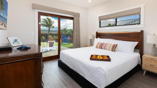ワイコロアにあるPEACEFUL PARADISE Quiet home with private poolのベッドと机と窓のある寝室