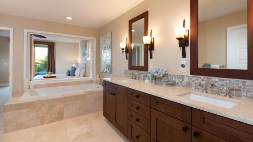 a bathroom with two sinks and a tub and a mirror at SAND CASTLE Modern KaMilo 4BR Home with Ocean Views Bikes in Waikoloa