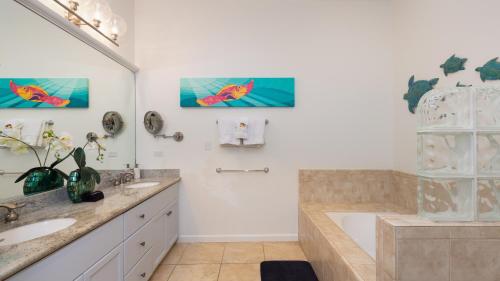 een badkamer met een bad en een wastafel bij ORCHID VILLA Inviting Fairways 3BR with Bikes and Private Beach Club in Waikoloa