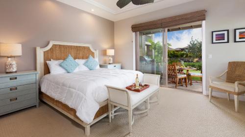 Un dormitorio con una cama, una mesa y una silla. en SEASHELL VILLA Lovely 3BR Kulalani Home with Private Beach Club Bikes, en Waikoloa