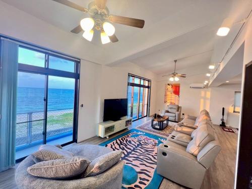 a living room with a couch and a ceiling fan at SEA BASE Onna in Onna