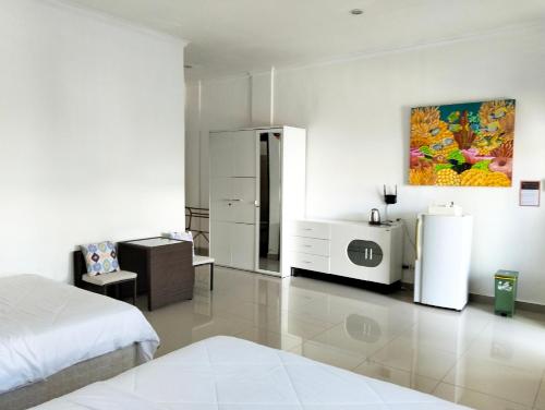 チャングーにあるMerry's House cangguの白いベッドルーム(ベッド1台、冷蔵庫付)