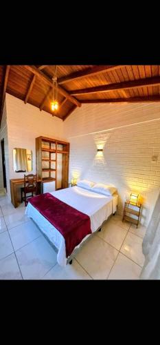a bedroom with a large bed in a room at Pousada Encantos do Rosa in Imbituba