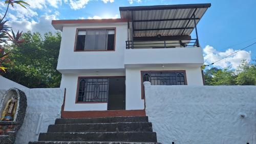 een wit huis met een trap ervoor bij Finca El Paraíso in Villeta