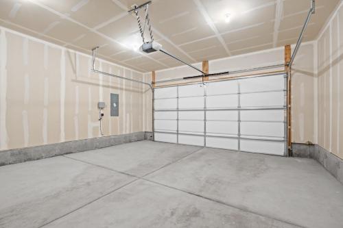 un garage avec des portes blanches et un sol en béton dans l'établissement Peaceful Idaho Falls Stay Fire Table Sleeps 8, à Idaho Falls