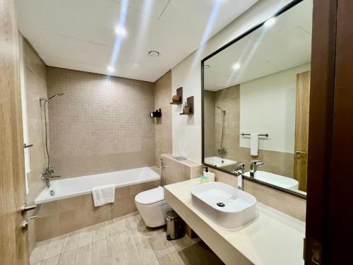 a bathroom with a sink and a toilet and a tub at Skyline 19 1 Residences in Dubai