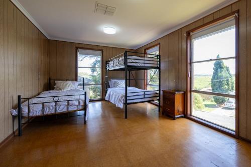 1 dormitorio con 2 literas y ventanas grandes en The Valley View Guest House, en Melbourne