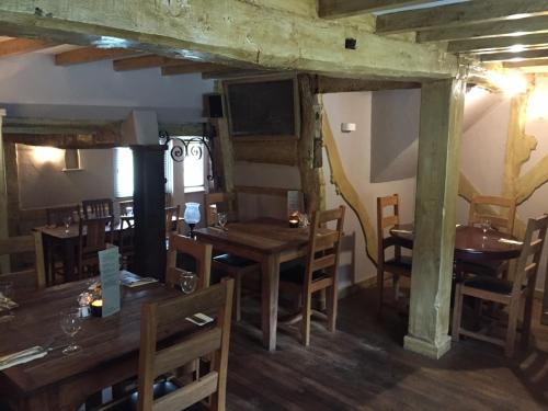 a dining room with wooden tables and chairs at The Old Three Pigeons in Nesscliffe