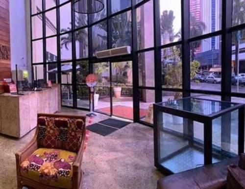 a living room with a glass table and a chair at Flat 502 América Tower, ao lado do Salvador Shopping in Salvador