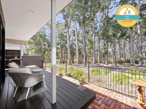 an outdoor deck with a table and chairs and a fence at Tall Trees Margaret River in Margaret River Town
