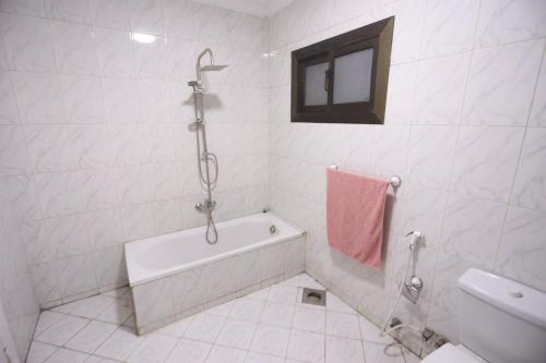 a white bathroom with a tub and a sink at Giza City Hotel-الجيزة سيتى اوتيل in Cairo